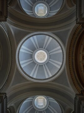 A perfectly centered vertical composition highlighting the geometric rhythm, radial lines, and soft lighting of the Neoclassical domes in Palermo Cathedral.