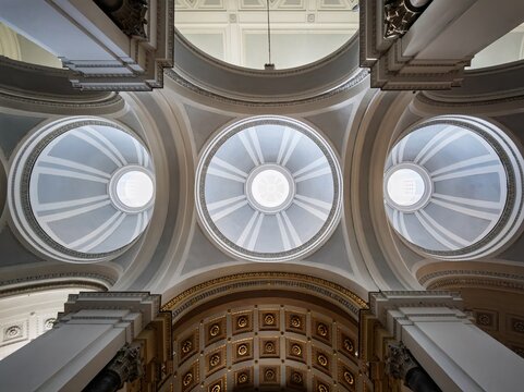 An artistic bottom-up composition highlighting the geometric harmony, classical domes, and subtle light play within the Neoclassical ceiling of Palermo Cathedral.