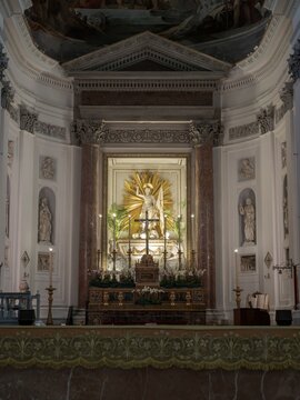 The main altar inside Palermo Cathedral featuring the marble statue of Risen Christ in a golden sunburst surrounded by classical red marble columns.