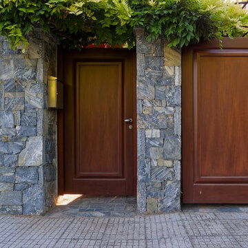 commercial real estate photograph of a luxury private home entrance with garage driveway gate and stone boundary wall in Athens.