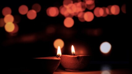 Traditional Diya Oil Lamps Glowing Against Dark Bokeh Background for Diwali Festival © Rara