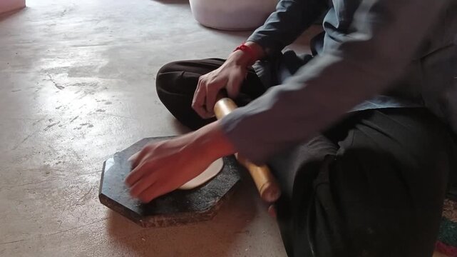 Young woman making traditional Indian roti flatbread at home