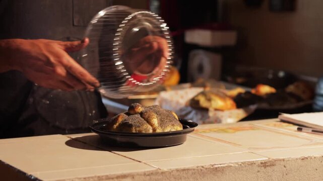 Baker packaging traditional mexican pan de muerto for dia de los muertos celebration, a close-up of a pastry chef carefully placing the bread of the dead in a container