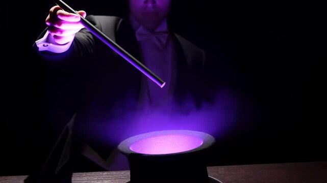 Magician raises wand as purple light glows from a top hat in a dark theatrical setting