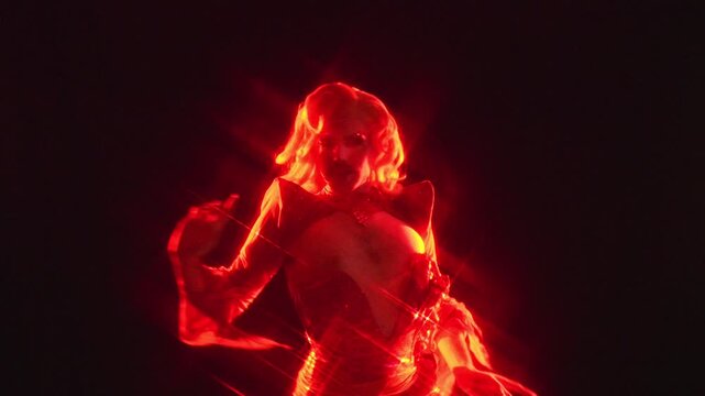 Fabulous drag queen dancing on stage under red light