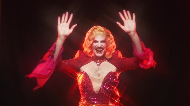 Flamboyant drag queen dancing in a sparkling red dress