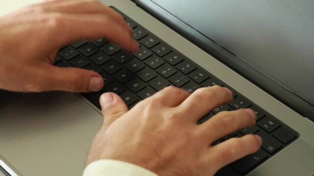 Hands typing on laptop keyboard upside down view close up of professional worker active fingerprints