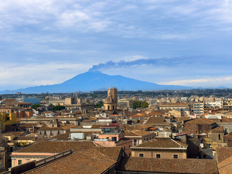 Panoramic cityscape of Catania with historic rooftops and Mount Etna volcano