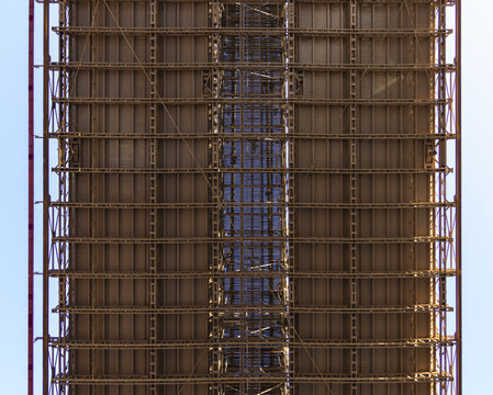 View of the intricate steel girders and structural trusses on the underside of the Brooklyn Bridge in New York, New York, United States.