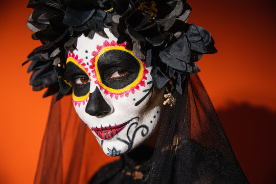 Young woman in sugar skull makeup celebrating Dia de los Muertos with style