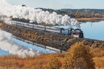 Retro steam train moves along the lake.  © serjiob74