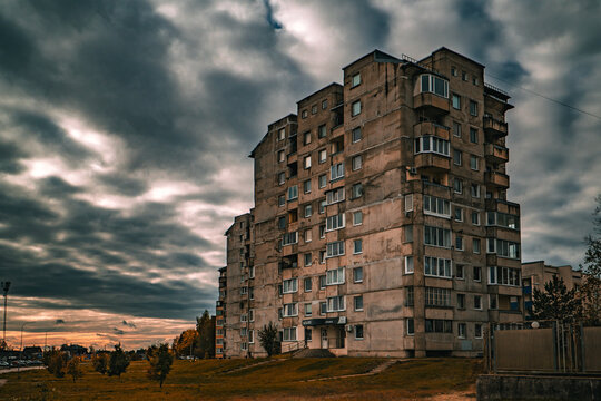 Gloomy Soviet-Era Apartment Building At Dusk With Dramatic Cloudy Sky