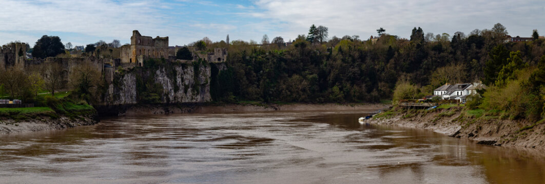 Chepstow Castle viewed across the muddy water of the Old Wye Bridge