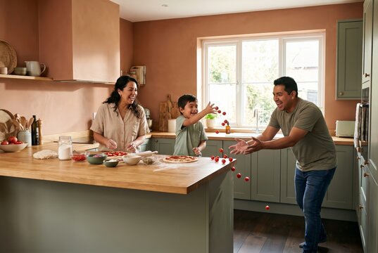 Happy family making pizza together and playing with food