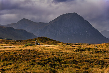 An off-road vehicle driving on a scenic road with Buachaille Etive Mor mountain in the background, Glen Coe, Scotland. © Tomasz German
