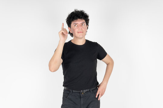 Young man pointing up with index finger having an eureka idea in studio