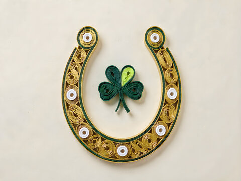 Quilled gold lucky horseshoe with green shamrock on cream background