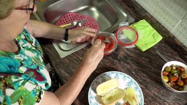 Older woman preparing dinner at home, real domestic lifestyle.