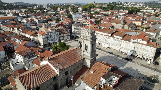 Aerial view of the historic St. Peter's Basilica surrounded by traditional terracotta-roofed buildings and cobblestone squares in the city center of Guimaraes, Braga, Portugal.