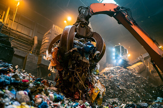 Large quantities of household waste are scooped up by a claw crane at the energy plant, where a massive mechanical grabber transfers the garbage into a processing pit. This modern recycling facility e