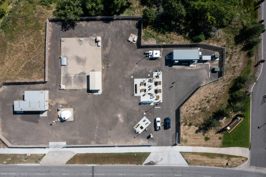 Aerial view of a water treatment facility with various tanks, equipment, and utility buildings situated within a fenced compound in Colorado, United States.