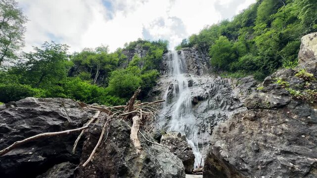 Low Angle View of Majestic Mountain Waterfall with Natural Sound Cascading Down Rocky Cliff Surrounded by Dense Green Forest in Artvin, Turkey