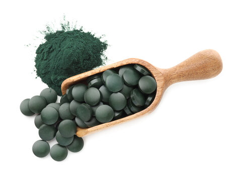 Green spirulina tablets in wooden scoop and powder isolated on white, top view