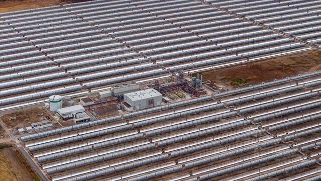 Aerial view of Central Termosolar Helioenergy 1, a concentrated solar power plant with rows of parabolic trough mirrors and a central facility in Ecija, Andalusia, Spain.
