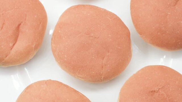 Italian soft round bread buns on a white plate, extreme close-up, rotating video.