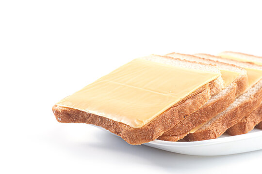 Slices of whole wheat toast bread with cheddar cheese slices arranged on white plate isolated on white background. Healthy breakfast, dairy product, quick snack and meal preparation concept.
