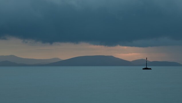 Navigation marker beneath dark clouds off Rafina, with Evia and Megalonisos, Greece