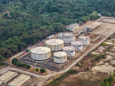 Aerial view of Pro Tank Terminal, featuring industrial fuel storage tanks, surrounding lush forest, and paved service areas in Samarinda, East Kalimantan, Indonesia.