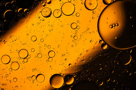 Abstract yellow oil drops floating in liquid macro view