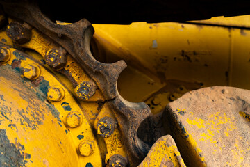 Close up rusty sprocket and crawler tracks chain of yellow bulldozer © Muhamad