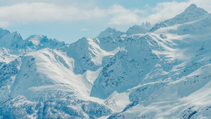 Panoramic snow-covered Mount Elbrus and surrounding Caucasus mountain peaks in clear winter light, crisp ridges and shadowed glaci © ossyffer