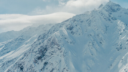 Mount Elbrus snow-covered rugged peaks in Caucasus Mountains panorama under soft daylight, aerial view, winter alpine landscape,sc © ossyffer