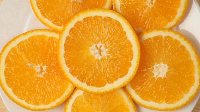 Fresh juicy sliced oranges rotating on a plate