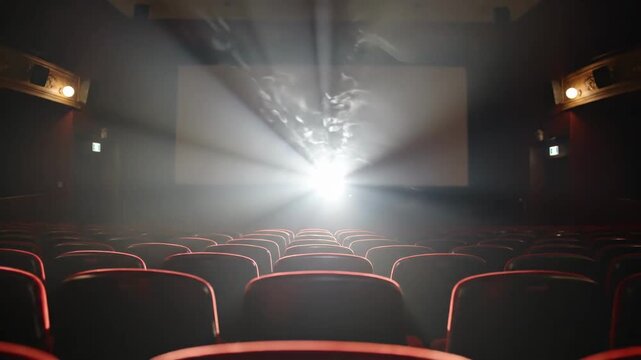 Tracking shot of projector beam sweeping across empty cinema auditorium rows toward illuminated screen in dark theater interior