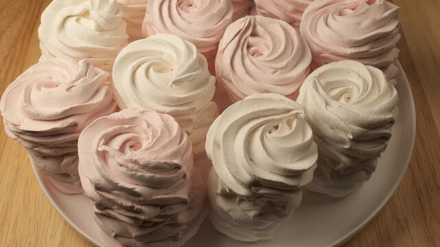 Pink and white zephyr marshmallow rotating on a plate