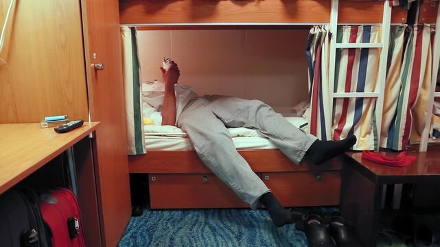 Exhausted ship employee lying down on his bunk bed after a long day of work to get some rest