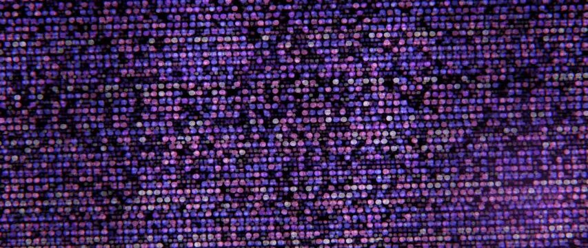 Colorful LED dot matrix shimmers in purple and blue abstract patterns on a dark background