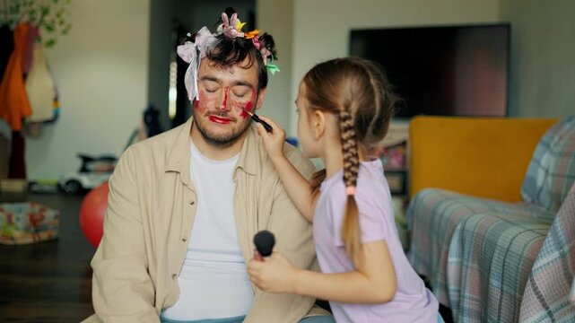 Patient father wearing funny face makeup smiling at daughters. Warm family life and leisure