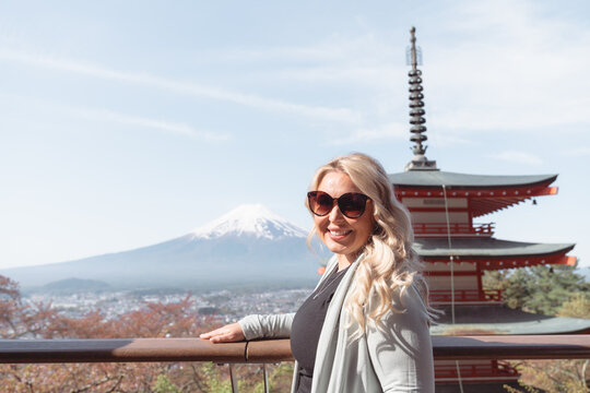 Blonde tourist woman poses at Chureito pagoda, Mt Fuji mountain viewpoint in Shimoyoshida, Japan
