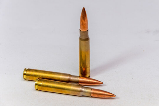 Three rifle cartridges isolated on white background with copper pointed bullets