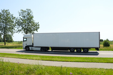 Truck cargo transportation on road in nature countryside landscape. Infrastructure industry, future planet, global warming and distribution themes. © Laura