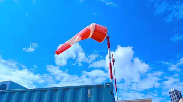 Orange and White Aviation Windsock Inflated by Wind Under Blue Sky