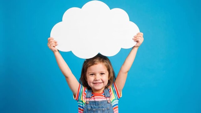 Happy little caucasian girl holding a blank white cloud speech bubble above her head for your message. Cute child model with an empty thought bubble for advertising copy space