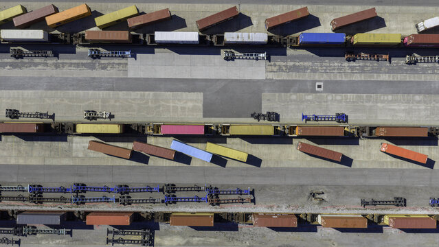 Aerial view of CSX's Radnor Yard and Nashville Intermodal train terminal featuring rows of colorful shipping containers on rail cars and empty chassis trailers in Nashville, TN, United States.