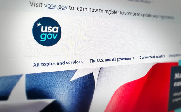 Close up of USA.gov website homepage showing government topics and services with patriotic flag, illustrative editorial backdrop