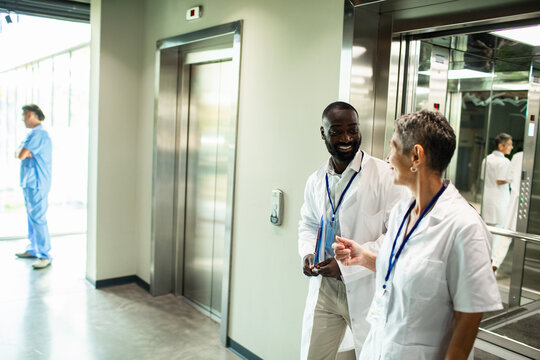 Doctors chatting by hospital elevator lobby